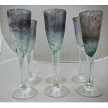 A set of six Tysoe glass flutes of iridescent bubble form raised on a circular foot,