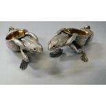 A pair of cast white metal salts with gilt washed interiors as a frog pulling an upturned snail