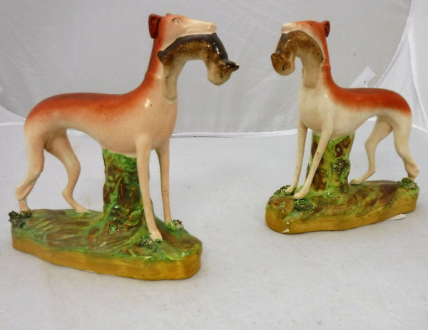 A pair of Victorian Staffordshire figures of "Greyhounds with hare quarry"