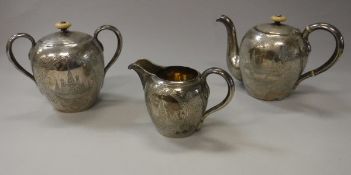 A circa 1900 Russian silver three piece teaset of ovoid form with engraved decoration of Moscow