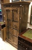 An Indonesian hardwood two door cupboard with wrought iron decoration