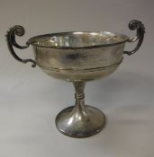 A George V silver trophy cup with two scrollwork handles,
