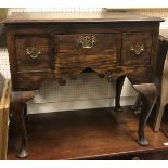 An oak lowboy, the plain top above a central drawer flanked by two deeper drawers,