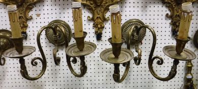A pair of brass twin light wall sconces with serpent head decoration together with two pairs of