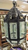 A modern black painted wrought iron and glass ceiling lantern,