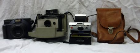 A Fuji Instax instant camera and two film packs, a Polaroid 103 instant land camera,