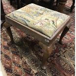 An 18th Century oak dressing stool with needlework drop in seat on cabriole legs to pad feet