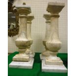 A set of four grey viened white marble column lamps of urn form raised on square sockel bases