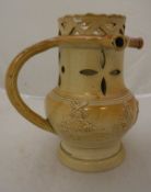 A circa 1800 salt glazed puzzle jug decorated with various topers