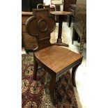 A pair of early 19th Century mahogany panel seated hall chairs with brass handles to the top rail