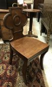 A pair of early 19th Century mahogany panel seated hall chairs with brass handles to the top rail