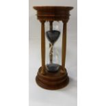 A modern walnut mounted blown glass "Urbino" hourglass sand timer bearing silver medallion to top