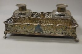 A Victorian pierced silver rectangular desk stand with two silver mounted cut glass inkwells (by