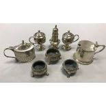 A collection of silver salts, peppers and mustards,