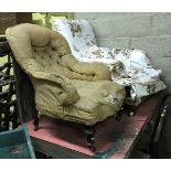 A Victorian upholstered armchair on turned walnut legs to brass caps and casters,