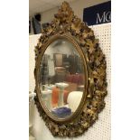 A Victorian carved giltwood and gesso framed oval wall mirror with grape and vine decoration in the