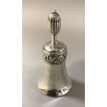 A silver table bell with scrolling acanthus band decoration and bearing monogram "A.S.