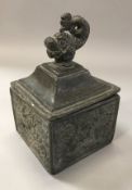 A 19th Century lead tobacco container, the lid with dolphin finial,