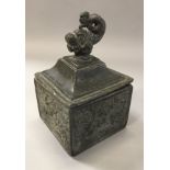 A 19th Century lead tobacco container, the lid with dolphin finial,