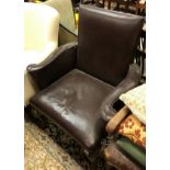 A 19th Century brown leather upholstered scroll arm chair on shell carved cabriole legs to pad feet