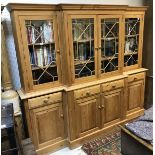 A modern pine breakfront bookcase cabinet with four astragal glazed cabinet doors over four drawers