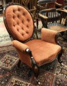 A Victorian walnut gentlemens salon chair with buttonback and showframe with red upholstery