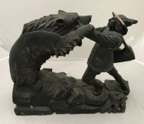 A black forest type carved treen ware figure group of man fighting bear