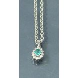 A white gold emerald and diamond set pendant