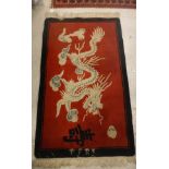 A Chinese rug, the red ground set with dragon decoration within a black border, approx.