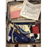 A suitcase and collection of Masonic regalia, badges, medallions, gauntlets, aprons,