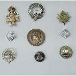 A collection of badges to include a silver mounted tortoiseshell badge for The Royal Artillery,