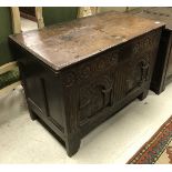 A 17th Century oak coffer with carved two panel front (with repairs and alterations)