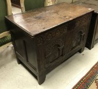 A 17th Century oak coffer with carved two panel front (with repairs and alterations)