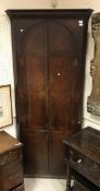 A late 18th Century oak corner cupboard, the moulded dentil cornice above two domed panelled doors,