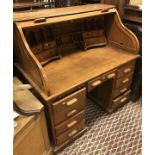A modern teak tambour topped desk with fitted interior over a central kneehold and drawer flanked