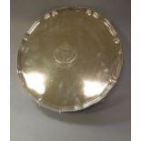 A George III silver salver with beaded edge and piecrust rim raised on four claw and ball feet,