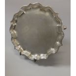 A George VI silver card tray in the 18th Century manner with piecrust rim raised on three hoof feet