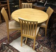 A modern stained beech kitchen table and four slat back oak dining chairs