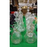 A collection of twelve decanters and ewers including one etched with insects playing billiards,