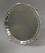 A George V silver card tray in the Georgian manner with beaded rim raised on four hoof feet (by