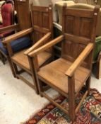 A pair of panelled back oak chairs