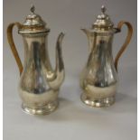 A pair of George V silver coffee pot and hot water jug of baluster form raised on a circular