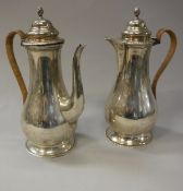 A pair of George V silver coffee pot and hot water jug of baluster form raised on a circular