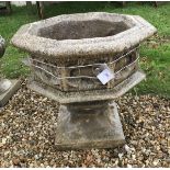 A composite stone urn of octagonal form with gothic style design