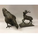 A modern bronze study of a feeding chicken and a copper patinated spelter figure of a ten point