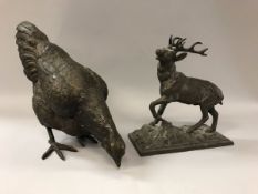 A modern bronze study of a feeding chicken and a copper patinated spelter figure of a ten point