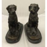 A pair of modern patinated bronze studies of seated dogs on marble bases