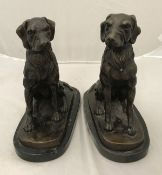 A pair of modern patinated bronze studies of seated dogs on marble bases