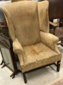 A 19th Century yellow floral upholstered wing back scroll arm chair on mahogany base