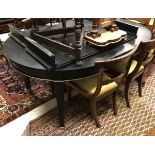 A modern ebonised and silver highlighted extending dining table in the Victorian taste with two